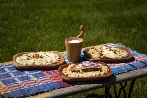 three pizzas on a picnic table with a cup of coffee at Hotel Telgárt - Turistické ubytovanie in Telgárt