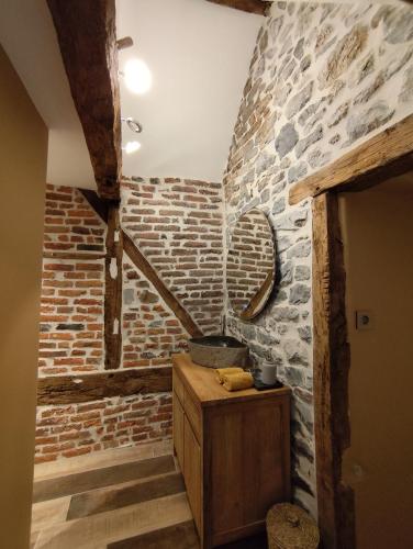 a room with a brick wall and a wooden cabinet at La Grange de Bonneville in Andenne