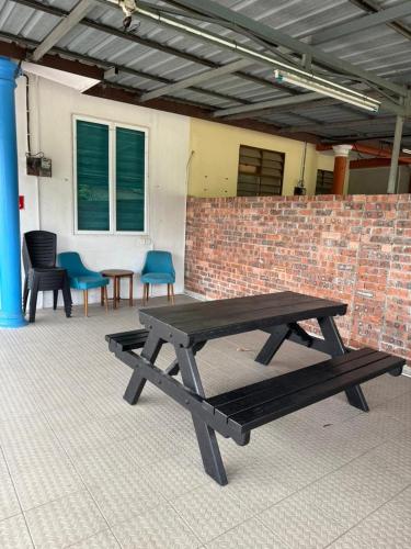 a picnic table in front of a brick wall at D'Iman Homestay Private Pool in Ketereh