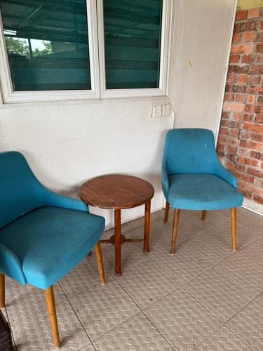 two chairs and a table and a table and chairs at D'Iman Homestay Private Pool in Ketereh