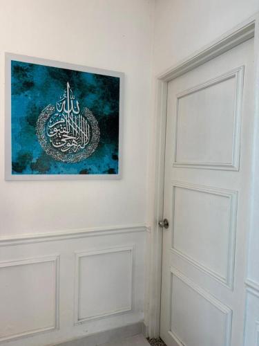 a white door with a painting on the wall at D'Iman Homestay Private Pool in Ketereh