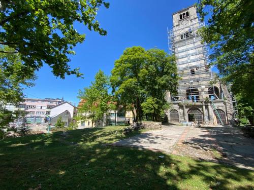 an old building with a tree in front of it at Apartments & Rooms Fountain in Bihać