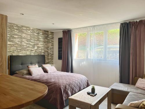 une chambre avec un lit, un canapé et une table dans l'établissement La Villa l'Oiseau Bleu proche de la plage et de Deauville !!! Awards 2025, à Blonville-sur-Mer