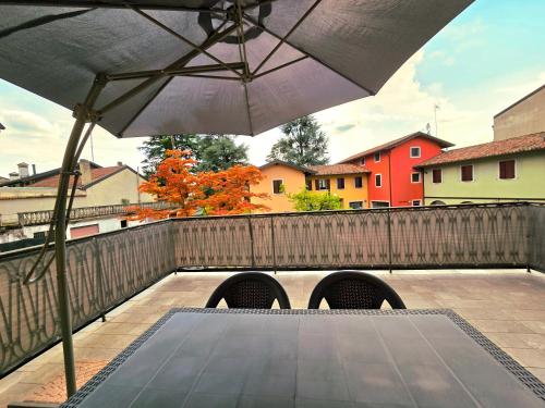 an umbrella sitting on top of a patio at Tricesimo Appartamento Suite in Centro Storico in Tricesimo