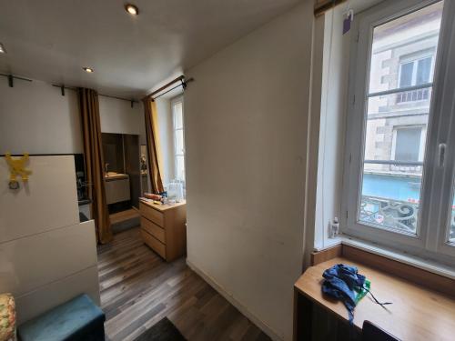 ein Wohnzimmer mit großem Fenster und Holzböden in der Unterkunft Sana in Saint-Brieuc
