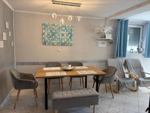 a dining room with a wooden table and chairs at Napsugár vendégház in Mezőkövesd