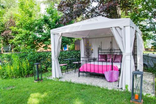 a bed in a gazebo in a yard at Pension Stissen Haus am See in Faak am See