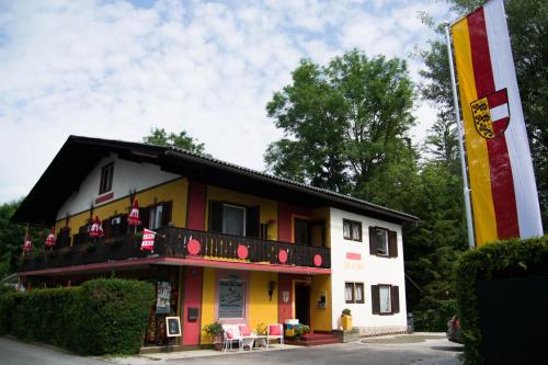 a building with a red yellow and white at Pension Stissen Haus am See in Faak am See