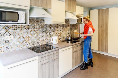 a woman standing in a kitchen preparing food at Bridge Hotel in Rīga