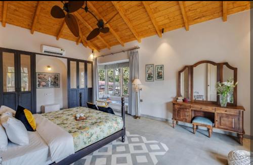 Un dormitorio con una cama grande y un escritorio. en Luxury 3Bhk Villa near Vagator, Goa, en Anjuna