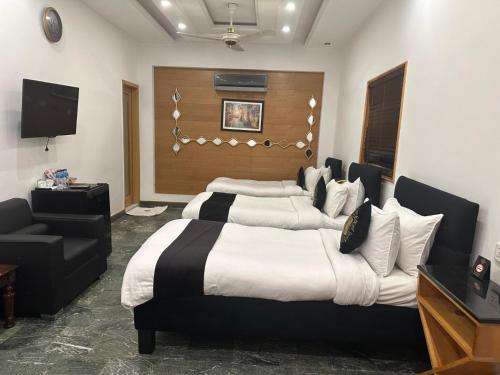 a bedroom with a large bed and a television at Lawrence View Hotel, Lahore in Lahore
