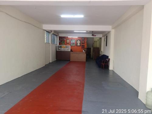 a long hallway with a red carpet in a room at Pvt Residency in Palni