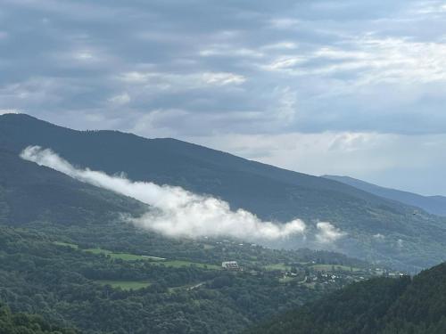a view of a mountain with smoke in the distance at Casa Rural Pirineu Nevà in Nevà