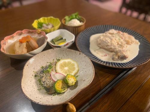 a table with plates of food and bowls of food at トガリハイランド白樺 in Iiyama