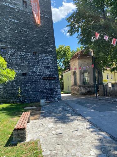 a brick building with a bench in front of it at Apartments & Rooms Fountain in Bihać
