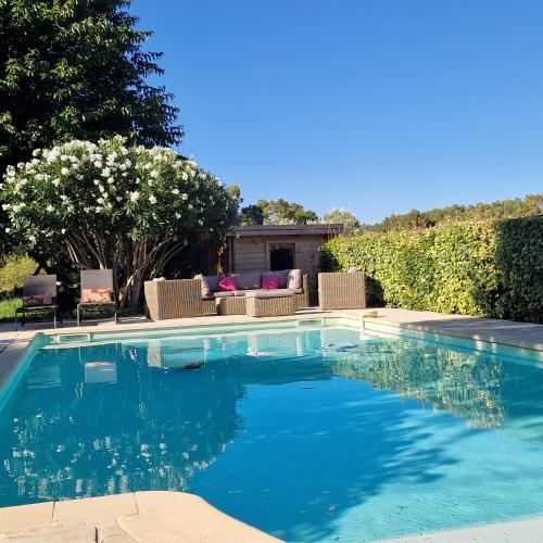 une piscine avec de l'eau bleue dans une cour dans l'établissement la Cigalette, à Peypin