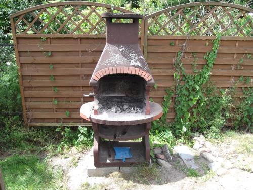 an outdoor brick oven in front of a wooden wall at Camping domki letniskowe in Warsaw