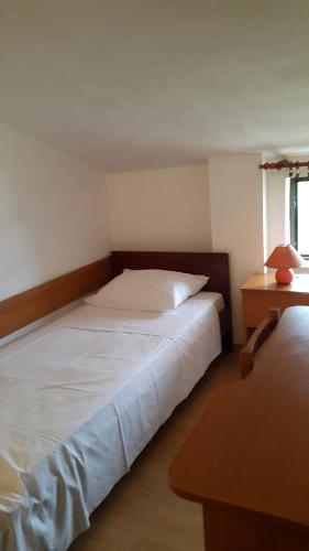 a bedroom with a bed and a table with a lamp at Apartments Ukić in Tribunj