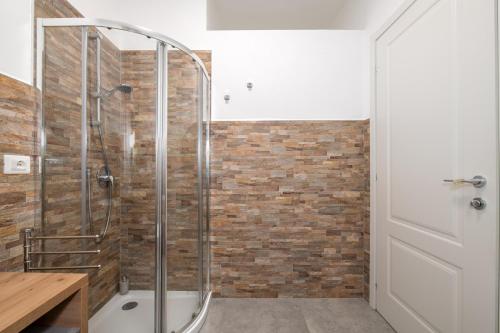 a shower in a bathroom with a brick wall at B&B I Girasoli in San Donato Milanese