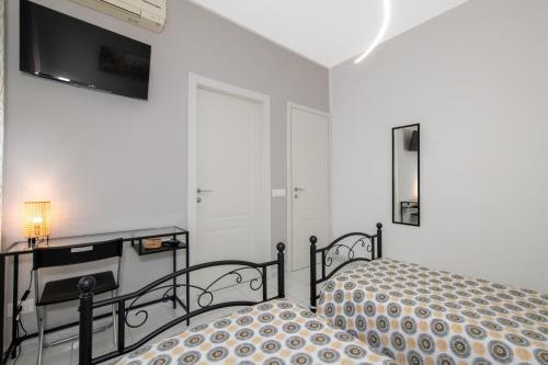 a bedroom with a bed and a television on a wall at B&B I Girasoli in San Donato Milanese