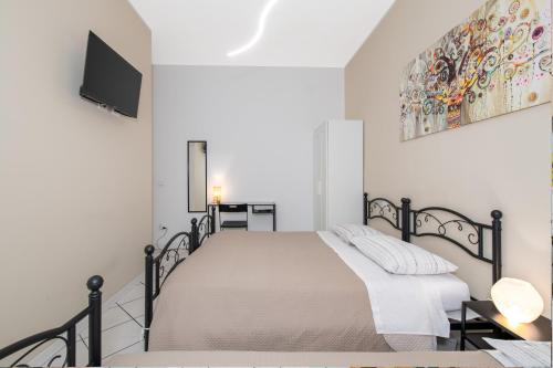 a white bedroom with a bed and a tv at B&B I Girasoli in San Donato Milanese