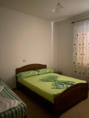 sypialnia z łóżkiem z zieloną kołdrą w obiekcie A&A Aparthotel w mieście Orikum
