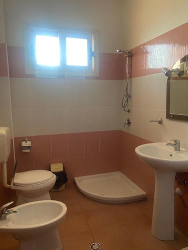 łazienka z dwiema toaletami i umywalką w obiekcie A&A Aparthotel w mieście Orikum