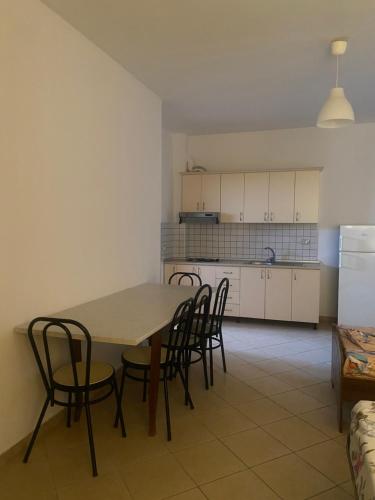 kuchnia i jadalnia ze stołem i krzesłami w obiekcie A&A Aparthotel w mieście Orikum