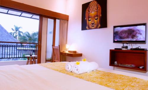 a bedroom with a bed with a television and a large headboard at Villa Sammy in Seminyak