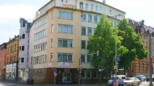 a building on a city street with cars parked in front at Komfort Hotel Ludwigsburg in Ludwigsburg