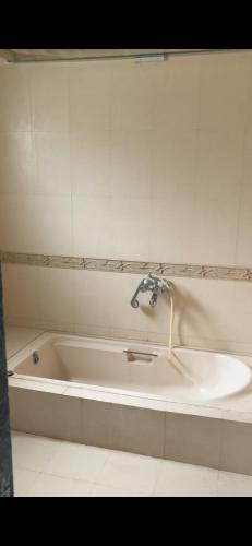 a bath tub with a faucet and a sink at Matoshri in Satara