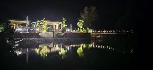 a house at night with a reflection in the water at Delta Lake House 1 in Velika Reka