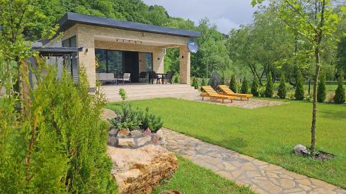 a garden with a house with a patio at Delta Lake House 1 in Velika Reka