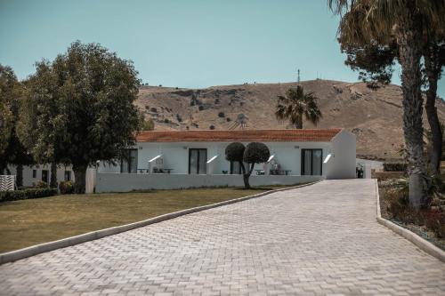 a white house with a mountain in the background at Aiora Resort in Pefki Rhodes