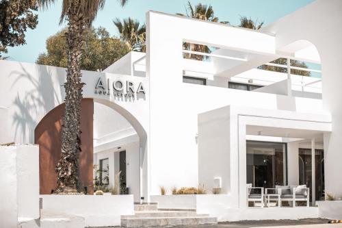 a white house with a palm tree in front of it at Aiora Resort in Pefki Rhodes