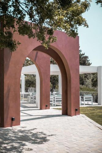 an archway leading into a park with white benches at Aiora Resort in Pefki Rhodes