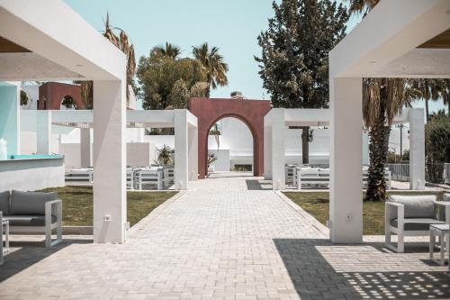 an archway leading to a resort with white chairs at Aiora Resort in Pefki Rhodes