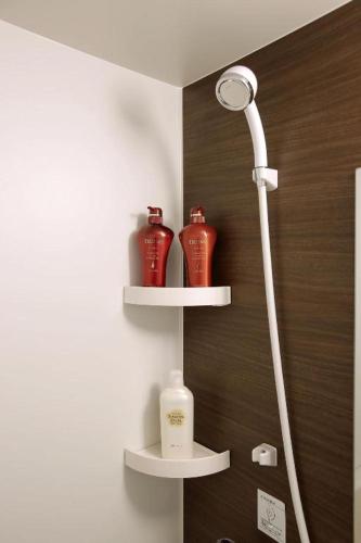 a bathroom with two red vases on shelves at Hotel Sunoak Kashiwanoha in Kashiwa
