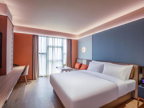 Ένα ή περισσότερα κρεβάτια σε δωμάτιο στο Orange Hotel Beijing Changping Future Science City