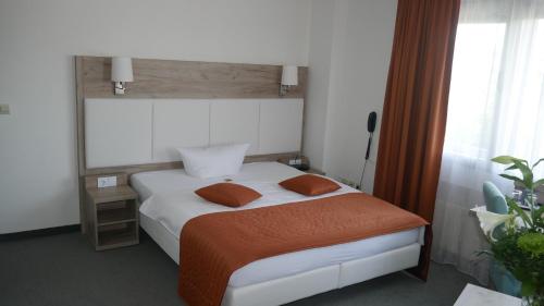 a bedroom with a white bed with two pillows at Komfort Hotel Ludwigsburg in Ludwigsburg