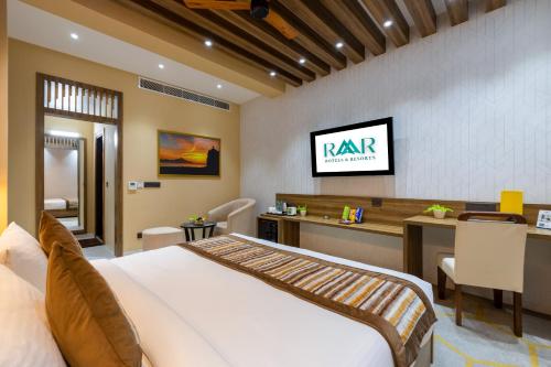 a bedroom with a bed and a desk and a tv at The SM Hotel By RMR Hotels in New Delhi