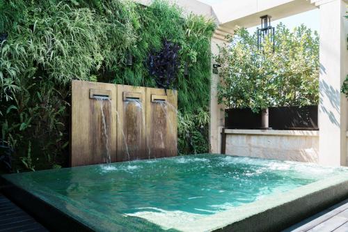 a swimming pool with a water fountain in a garden at Casa 300Mila in Lecce
