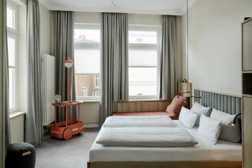 a hotel room with a bed and two windows at LIHO - einfach Lübeck in Lübeck