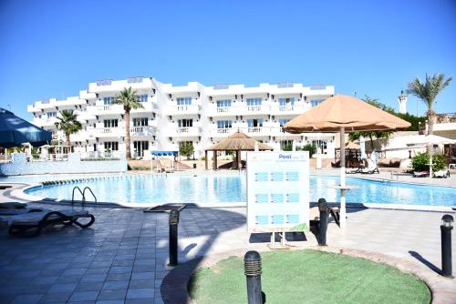 a large hotel with a pool and a sign in front of it at Hollywood Aqua Park Sharm El-Sheikh in Sharm El Sheikh