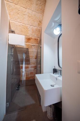 a bathroom with a sink and a shower at La Pupa coi baffi - Edificio Storico in Centro in Conversano