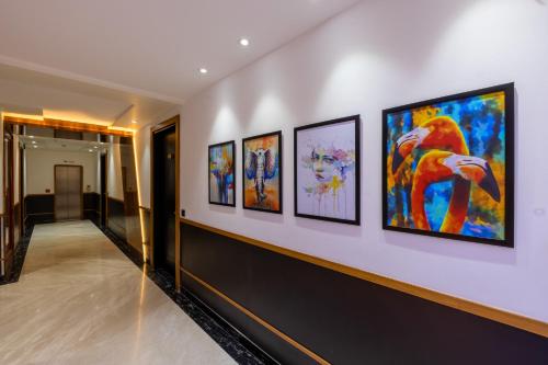 a hallway with a bunch of paintings on a wall at The SM Hotel By RMR Hotels in New Delhi