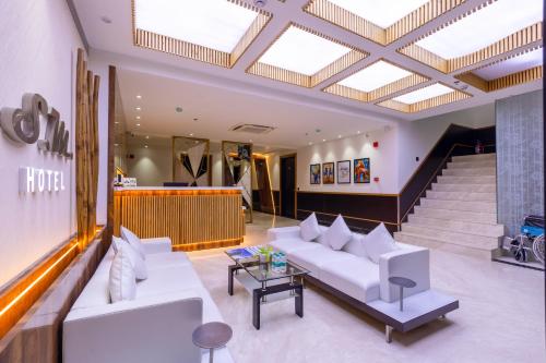 a lobby with white couches and a staircase at The SM Hotel By RMR Hotels in New Delhi