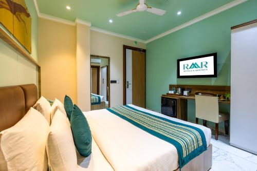 a bedroom with a king sized bed and a desk at The SM Hotel By RMR Hotels in New Delhi