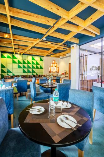 a dining room with a table and blue chairs at The SM Hotel By RMR Hotels in New Delhi