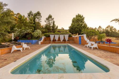 a swimming pool with lounge chairs and a swimming pool at Quinta do Barrieiro - Art Selection by Maria Leal da Costa in Marvão